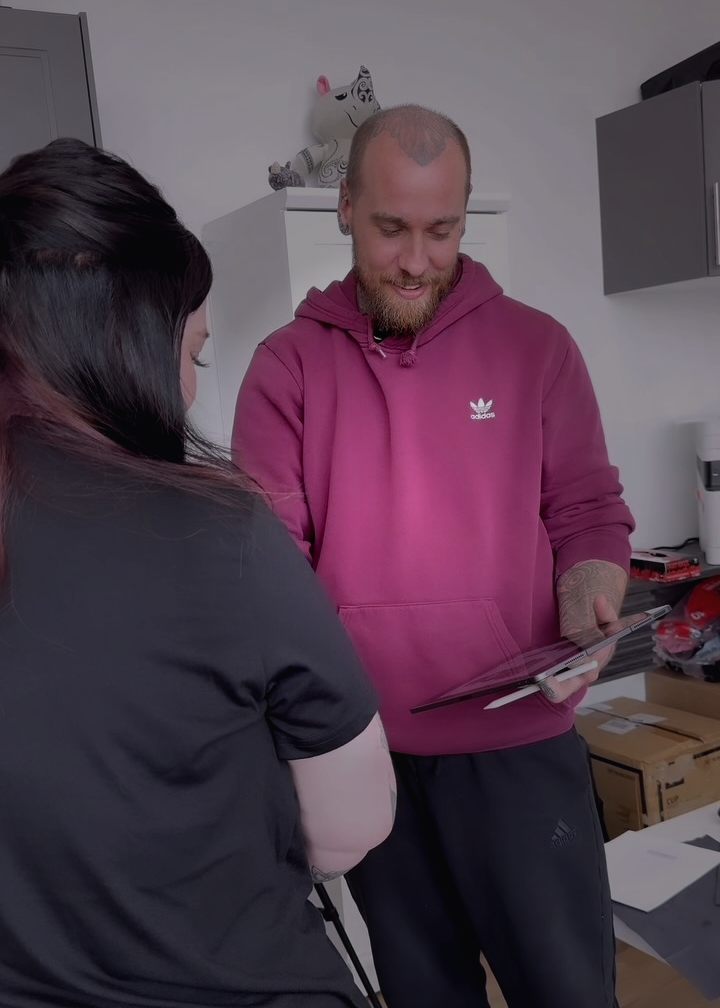 Ryan showing a client the design on a tablet before the session starts.