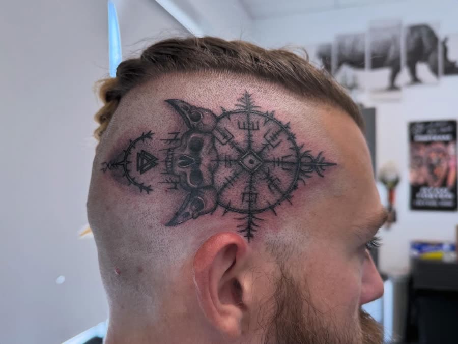 Black and grey ornamental compass tattooed on the side of a head.
